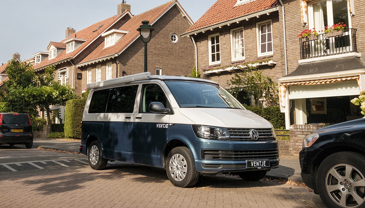 Gele Ventje T7 camper met hefdak open en keuken uitgestald. 